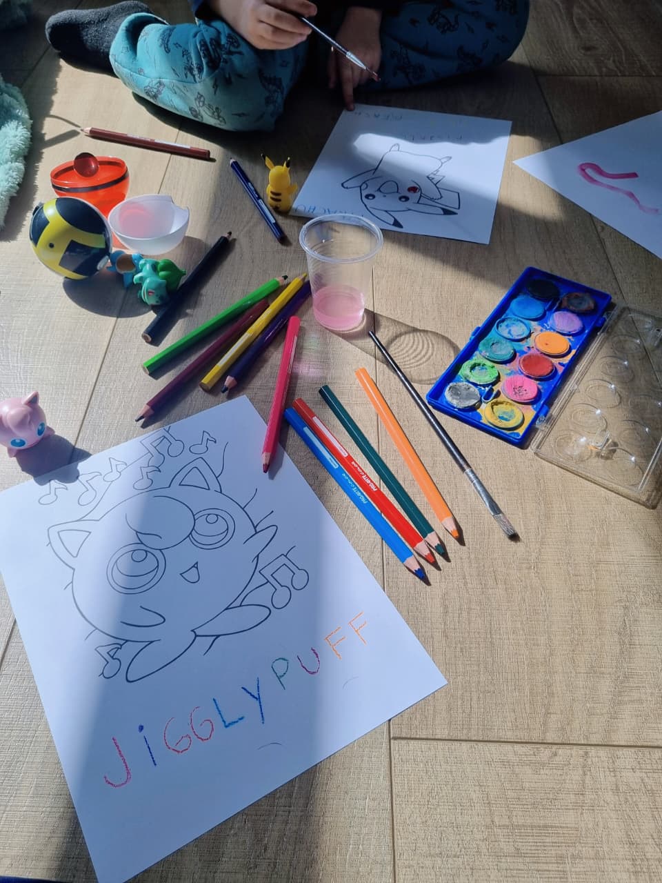 Lápices de colores, acuarelas y un dibujo durante una sesión real