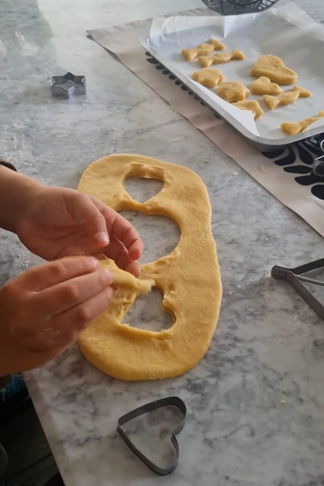 Manos pequeñas preparando galletas con moldes